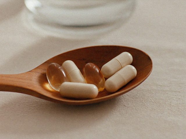 Berberine capsules on a wooden spoon